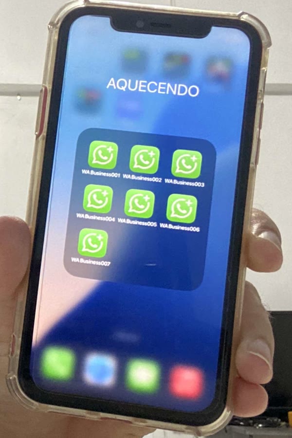 Tela de um iPhone com uma pasta chamada Aquecendo contendo os apps WA Business001 a WA Business007