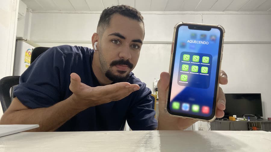Nathan, da NA Digital, segurando um iPhone com sete contas de WhatsApp Business instaladas na mesma tela